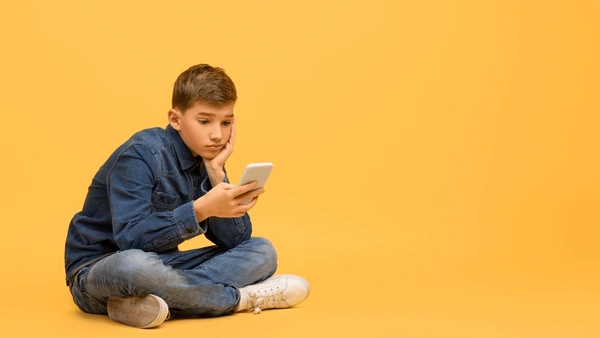 bored-teen-boy-using-smartphone-600nw-2412705601